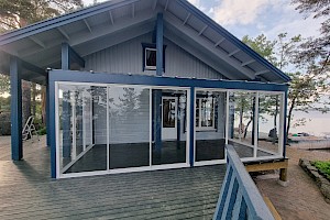 Tyylikkäästi mökkiin istuva liimapuurunkoinen lasiterassi