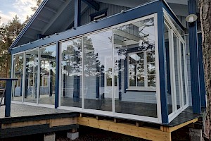 Tyylikkäästi mökkiin istuva liimapuurunkoinen lasiterassi