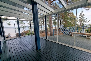 Tyylikkäästi mökkiin istuva liimapuurunkoinen lasiterassi