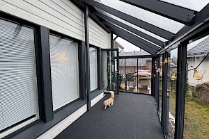 Harmaa liimapuurunkoinen lasiterassi